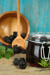 Tasty blackberry jam and fresh berries, on wooden table