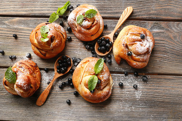 Tasty buns with berries on table close-up