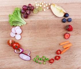 Different slices of vegetables and berries on wooden table