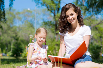 girl and a young woman reading a book together