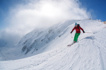 Fototapeta na wymiar Skier against blue sky in high mountains