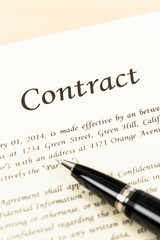 Business contract document on cream color paper and pen