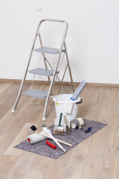 Wohnung streichen mit Farbroller, Pinsel, Eimer, Leiter