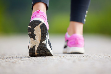Runner feet running on road closeup on shoe