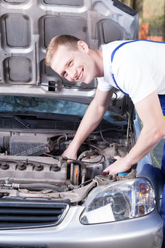 Repairman fixing car engine