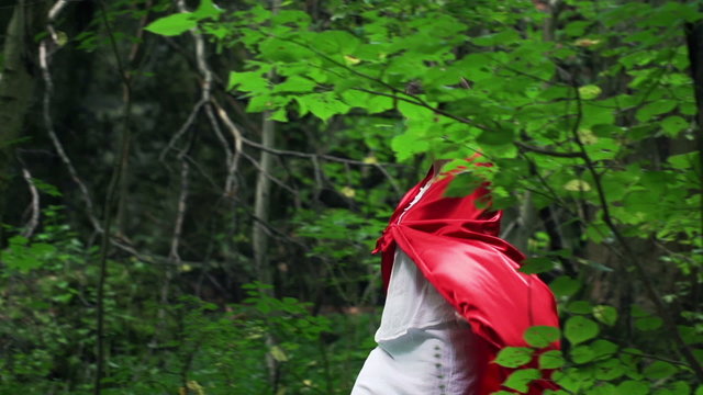 Beautiful red riding hood walking in forest, super slow motion