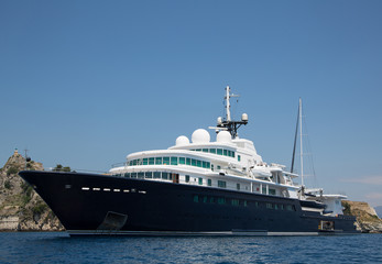 Fototapeta na wymiar Luxuriöse Mega Yacht mit Segelschiff an Bord