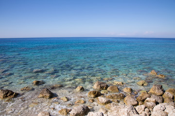 Steiniger Strand mit blauem Wasser und Blick zum Horizont