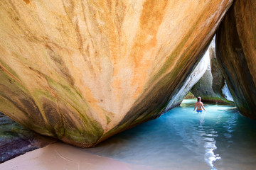 Young girl at cave on tropical beach