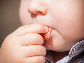 Closeup of cute baby boy eating something
