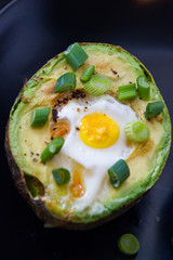 Eggs baked in avocado garnished with green onions