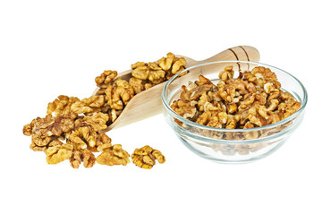 Handful of walnuts in scoop and glass bowl isolated.