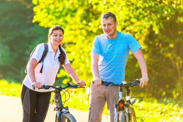 young couple on the weekend to ride a bike in the park