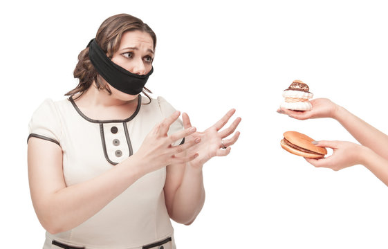 Plus size woman gagged stretching hands to junk food