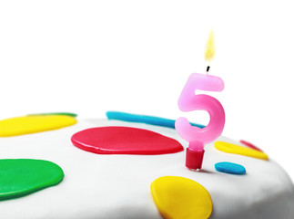 Burning candle with the number five on a birthday cake