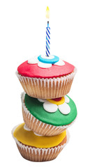 Pyramid of three colorful cupcakes with burning candle