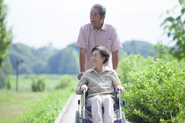 車椅子で散歩をする夫婦