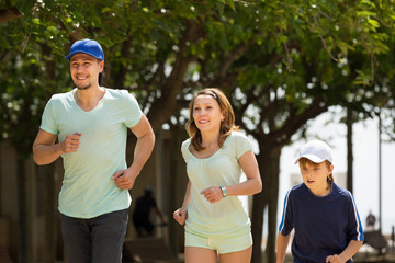 Happy family with child running in park