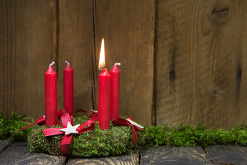Erster Advent: eine brennende Kerze am Adventskranz