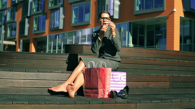 Businesswoman sitting and using red lipstick  
