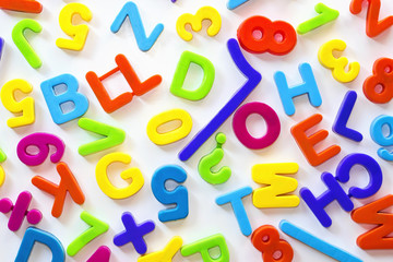 Letras y números de distintos colores sobre superficie blanca