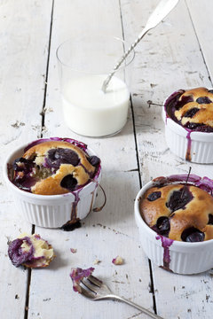 french clafoutis with cherries with milk in glass