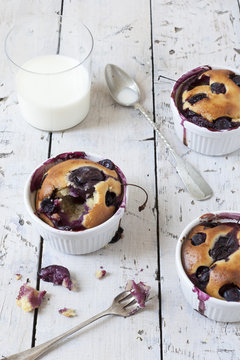 clafoutis with blueberries and cherries with milk in glass