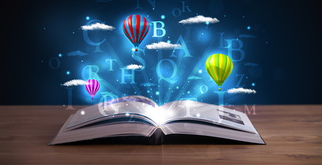 Open book with glowing fantasy abstract clouds and balloons