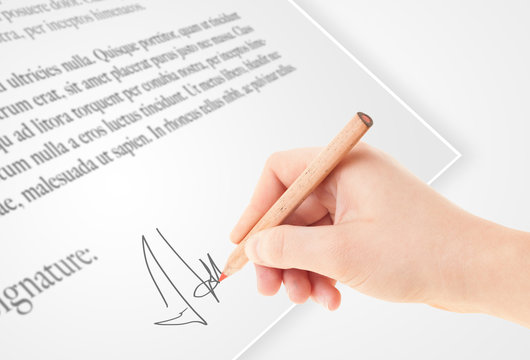 Hand writing personal signature on a paper form