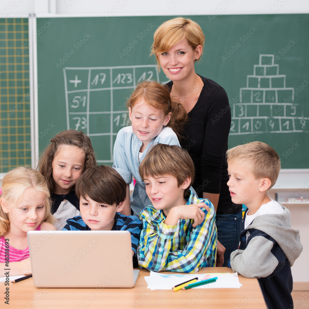 Wall mural lächelnde lehrerin mit schulkindern am laptop