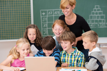 lachende schulkinder schauen auf laptop