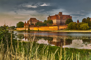 HDR image of medieval castle in Malbork at night with reflection