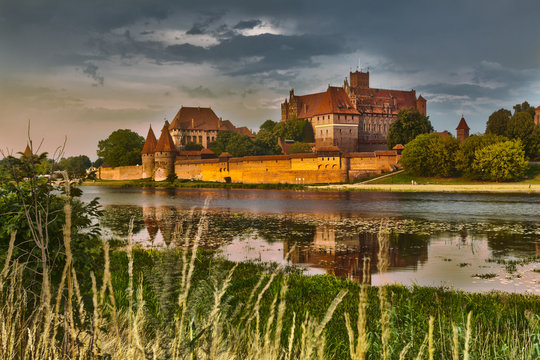 Fototapeta HDR image of medieval castle in Malbork at night with reflection