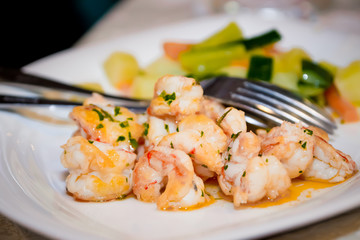 Fried shrimps in sauce with herbs and steamed vegetables