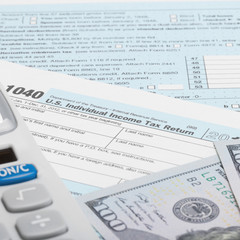 Fototapeta premium US Tax Form 1040 with calculator and US dollars - 1 to 1 ratio