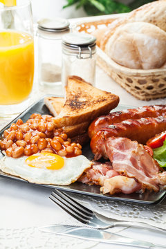 Full English breakfast with bacon, sausage, egg, baked beans and