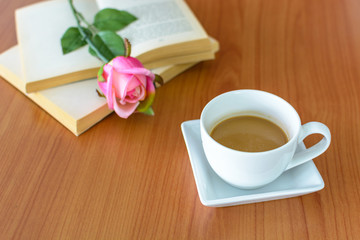 Close up of cup of coffee with pink rose