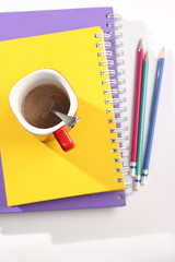 Notebook and coffee on table top view.