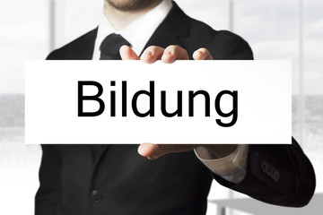 mann hält schild Bildung