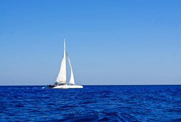 Fototapeta na wymiar White boat with sails in the Mediterranean