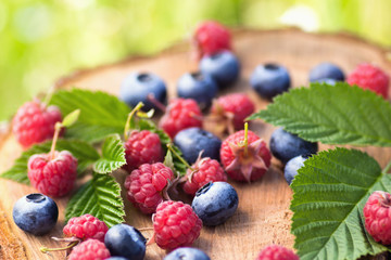 Blueberry and raspberry on wooden surface