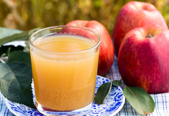 Glass of apple juice on blue plate