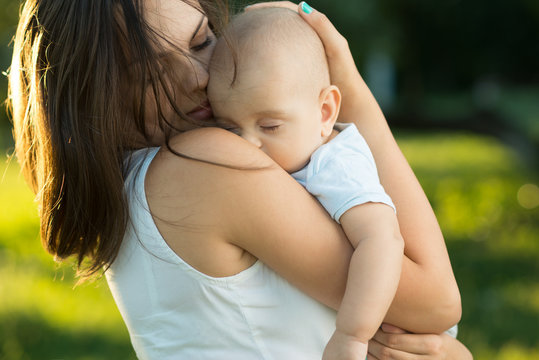 Happy Mother Holding A Young Sleeping Son