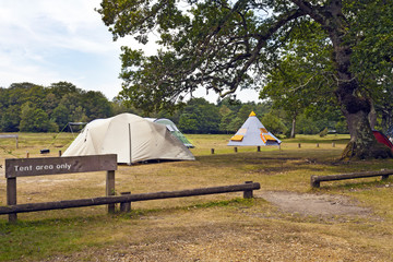 Big family tents and tepee in a camping ground under trees