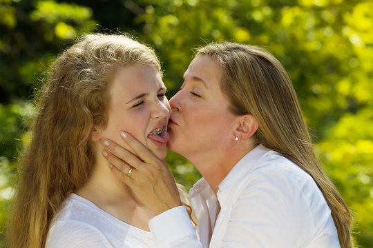 Teenage daughter not happy from her mother kissing her
