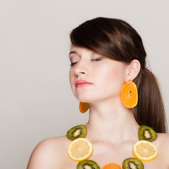 Diet. Girl with necklace of fresh citrus fruits