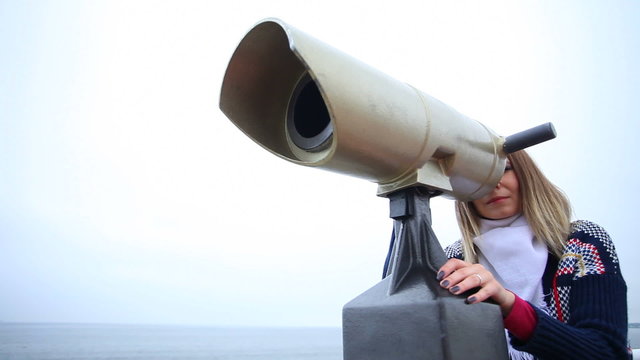 Woman looking through the binoculars. Full HD  motorized slider