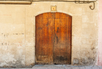 Fototapeta na wymiar Ancient wooden door in stone wall, France, Roussillon