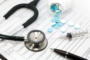 stethoscope syringe and pills on blank Patient information