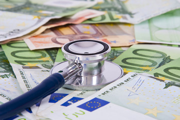 euro banknotes and coins with stethoscope, financial health